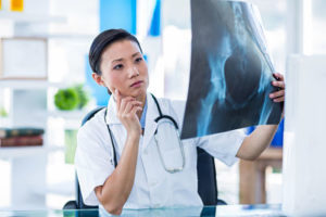 Concentrated doctor analyzing X-rays in medical office